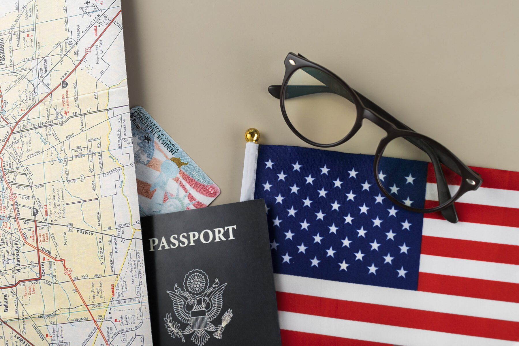 Passport, green card, US flag, and a map representing the path to permanent residency